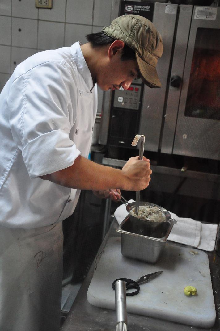 21 year old apprentice TJ Abello assists Chef Ariel in preparations